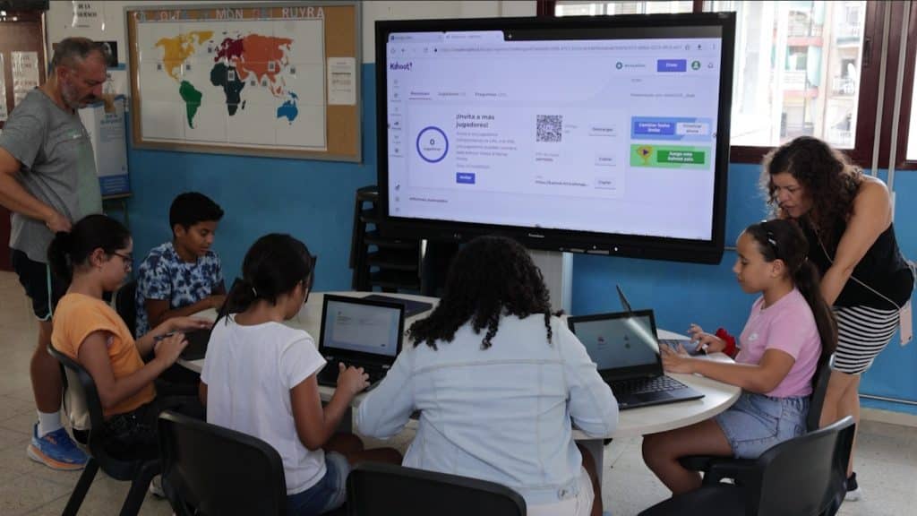 alumnes de l'escola Joaquim Ruyra a classe amb professor i col·laboradors