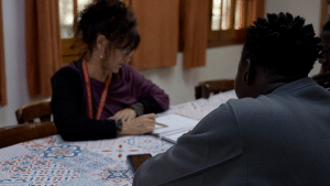 Educadora amb alumnes menors migrats en un centre d'atenció d'urgència