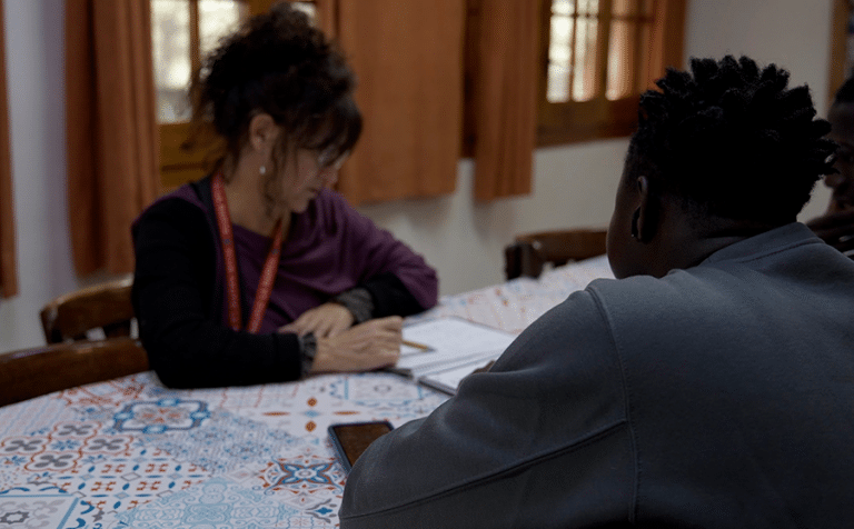 Educadora amb alumnes menors migrats en un centre d'atenció d'urgència