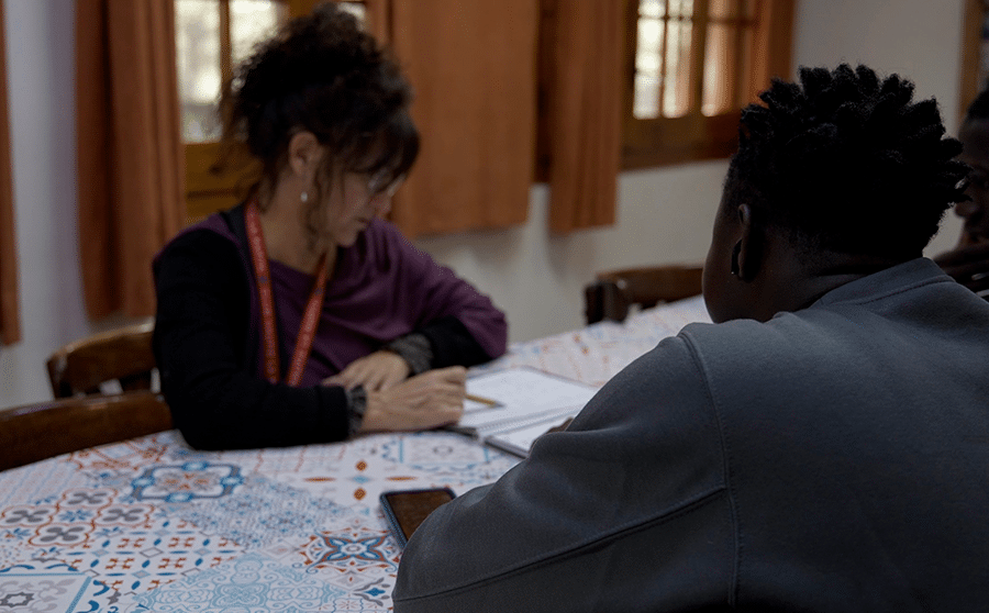 Educadora amb alumnes menors migrats en un centre d'atenció d'urgència
